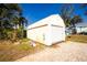 Exterior view of the property's detached storage shed with a roll-up garage door at 13204 Kakapo Ave, Port Charlotte, FL 33981