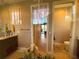 Neutral bathroom with vanity, toilet, and an open doorway to the living area at 13830 Begonia Cir, Port Charlotte, FL 33981
