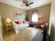 Cozy bedroom featuring a daybed, two chairs, a ceiling fan, and a modern abstract painting at 13830 Begonia Cir, Port Charlotte, FL 33981
