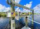 View of a boat lift with a control panel beside a calm canal under a clear blue sky at 13830 Begonia Cir, Port Charlotte, FL 33981