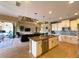 Open concept kitchen boasts a large island with seating and stainless steel appliances, seamlessly connecting to the living area at 13830 Begonia Cir, Port Charlotte, FL 33981
