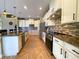 Stylish kitchen with granite countertops, stainless steel appliances, tile backsplash, island, and white cabinetry at 13830 Begonia Cir, Port Charlotte, FL 33981