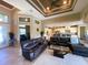 Bright living room featuring tile floors, a tray ceiling, and an open layout connected to the kitchen at 13830 Begonia Cir, Port Charlotte, FL 33981