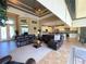 Open-concept living room with kitchen and dining area, leather sofas, coffered ceiling, and tile floors at 13830 Begonia Cir, Port Charlotte, FL 33981