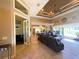 Spacious living room featuring tile floors, leather furniture, coffered ceiling, and an open layout at 13830 Begonia Cir, Port Charlotte, FL 33981