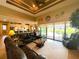 Spacious living room showcasing tile floors, a tray ceiling, and an open layout flowing into the kitchen at 13830 Begonia Cir, Port Charlotte, FL 33981