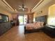Comfortable main bedroom with tray ceilings, fan, lanai access, and tile flooring at 13830 Begonia Cir, Port Charlotte, FL 33981