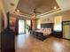Spacious primary bedroom with tray ceiling, tiled floor, and sliding doors to screened patio at 13830 Begonia Cir, Port Charlotte, FL 33981