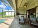 Screened patio with two chairs, ceiling fan, outdoor kitchen and view of pool at 13830 Begonia Cir, Port Charlotte, FL 33981