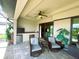 Screened patio with two chairs, ceiling fan, outdoor kitchen and access to backyard at 13830 Begonia Cir, Port Charlotte, FL 33981