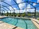 Screened-in pool offers a refreshing oasis with clear blue water and views of the serene canal at 13830 Begonia Cir, Port Charlotte, FL 33981