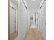 Hallway with wood floors, sliding closet doors, and view into bathroom at 1425 Park Beach Cir # 1310, Punta Gorda, FL 33950