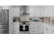 Well-appointed kitchen with white cabinets, stainless steel appliances, and a stylish tile backsplash at 1425 Park Beach Cir # 1310, Punta Gorda, FL 33950