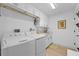 Bright laundry room with white cabinets, sink, and modern washer and dryer units for efficient home chores at 1425 Park Beach Cir # 1310, Punta Gorda, FL 33950