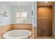 Bathroom featuring a large soaking tub with tile surround, window and a separate tiled shower at 15104 Aldama Cir, Port Charlotte, FL 33981