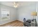 Bedroom featuring a ceiling fan, window, desk, and wood-look flooring, creating a comfortable workspace at 15104 Aldama Cir, Port Charlotte, FL 33981