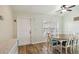 Cozy dining room features wood floors, a ceiling fan, a white door, and a charming table with chairs at 15104 Aldama Cir, Port Charlotte, FL 33981
