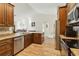 Spacious kitchen features stainless steel appliances, wood floors, granite counters, and seamless access to the living area at 15104 Aldama Cir, Port Charlotte, FL 33981