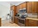 Modern kitchen features stainless steel appliances, wood floors, granite counters, and ample cabinet space at 15104 Aldama Cir, Port Charlotte, FL 33981