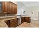 Spacious kitchen features stainless steel appliances, wood floors, granite counters, and seamless access to the living area at 15104 Aldama Cir, Port Charlotte, FL 33981