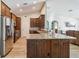 Open-concept kitchen features stainless steel appliances, wood floors, granite counters, and breakfast bar at 15104 Aldama Cir, Port Charlotte, FL 33981