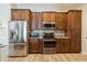 Modern kitchen features stainless steel appliances, wood floors, granite counters, and ample cabinet space at 15104 Aldama Cir, Port Charlotte, FL 33981