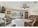 Spacious living room features tile floors, a ceiling fan, a sliding glass door with a view of the pool at 15104 Aldama Cir, Port Charlotte, FL 33981