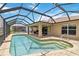 Relax in the heated, salt water pool surrounded by a spacious screened enclosure with an outdoor kitchen at 15104 Aldama Cir, Port Charlotte, FL 33981