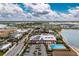An aerial view showcasing the community with commercial buildings, pool, lake, and homes at 16965 Hawk Ct, Punta Gorda, FL 33982