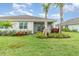 Well-maintained backyard featuring lush grass, landscaped flowerbeds, and a screened patio with a view of the lawn at 16965 Hawk Ct, Punta Gorda, FL 33982