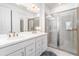 Bathroom featuring double sinks, a vanity with a white countertop, and a glass-enclosed shower at 16965 Hawk Ct, Punta Gorda, FL 33982