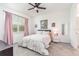Bright bedroom with a ceiling fan, large window, and bed dressed in floral patterned bedding at 16965 Hawk Ct, Punta Gorda, FL 33982