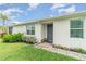 A quaint front entrance with a gray door and well-maintained landscaping invites you into this lovely home at 16965 Hawk Ct, Punta Gorda, FL 33982