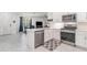 Well-lit kitchen featuring stainless steel appliances, white cabinetry, and an adjacent dining area at 16965 Hawk Ct, Punta Gorda, FL 33982