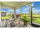 Lanai overlooking a pond, with a dining table, seating, plants, and views of the neighborhood at 16965 Hawk Ct, Punta Gorda, FL 33982