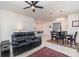 Open-concept living room featuring tile floors, neutral walls, and a black leather sofa with adjacent dining area at 16965 Hawk Ct, Punta Gorda, FL 33982