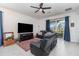 Cozy living room with a large TV, comfortable black leather furniture, and a view of the backyard at 16965 Hawk Ct, Punta Gorda, FL 33982