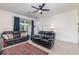 Comfortable living room featuring black leather sofas, a modern ceiling fan, and bright natural light at 16965 Hawk Ct, Punta Gorda, FL 33982