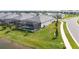 Backyard with a screened-in pool, lush green lawn, and partial view of a tranquil pond at 17557 Santorini Ct, Venice, FL 34293