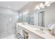 Bright bathroom features a double vanity, frameless shower, and stylish fixtures, offering a modern and functional design at 17557 Santorini Ct, Venice, FL 34293