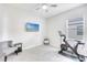 Bright bedroom with a ceiling fan, large closet, and neutral tile floor; ideal for a home gym or extra flex space at 17557 Santorini Ct, Venice, FL 34293