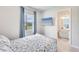 Well-lit bedroom offers a view into the en suite bath, a wall-mounted TV, and modern comforts at 17557 Santorini Ct, Venice, FL 34293