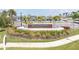 Well-manicured Wellen Park Golf & Country Club entrance with lush landscaping and clear signage at 17557 Santorini Ct, Venice, FL 34293
