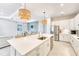 Bright open kitchen with island, stainless steel appliances and modern cabinetry provides an inviting space for cooking and gathering at 17557 Santorini Ct, Venice, FL 34293