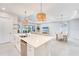Modern kitchen featuring a large island, quartz countertops, stainless steel appliances and seamless living-dining space at 17557 Santorini Ct, Venice, FL 34293