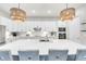 Modern kitchen with a large center island, quartz countertops, stainless steel appliances, and custom backsplash at 17557 Santorini Ct, Venice, FL 34293