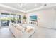 Bright and inviting living room with access to outdoor patio, features neutral furniture, and stylish decor at 17557 Santorini Ct, Venice, FL 34293