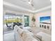 Bright living room with tile floors, a large comfortable couch, and sliding glass doors leading to an outdoor area at 17557 Santorini Ct, Venice, FL 34293