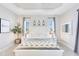 Bright main bedroom showcases a modern design with a white bed frame, recessed lighting, and coordinated nightstands at 17557 Santorini Ct, Venice, FL 34293