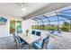 Covered outdoor dining area overlooking a screened-in pool and spa with a view of the surrounding community at 17557 Santorini Ct, Venice, FL 34293